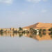 Sahara Desert Buildings along a lake filled by heavy rainfall in the desert town of Merzouga on O